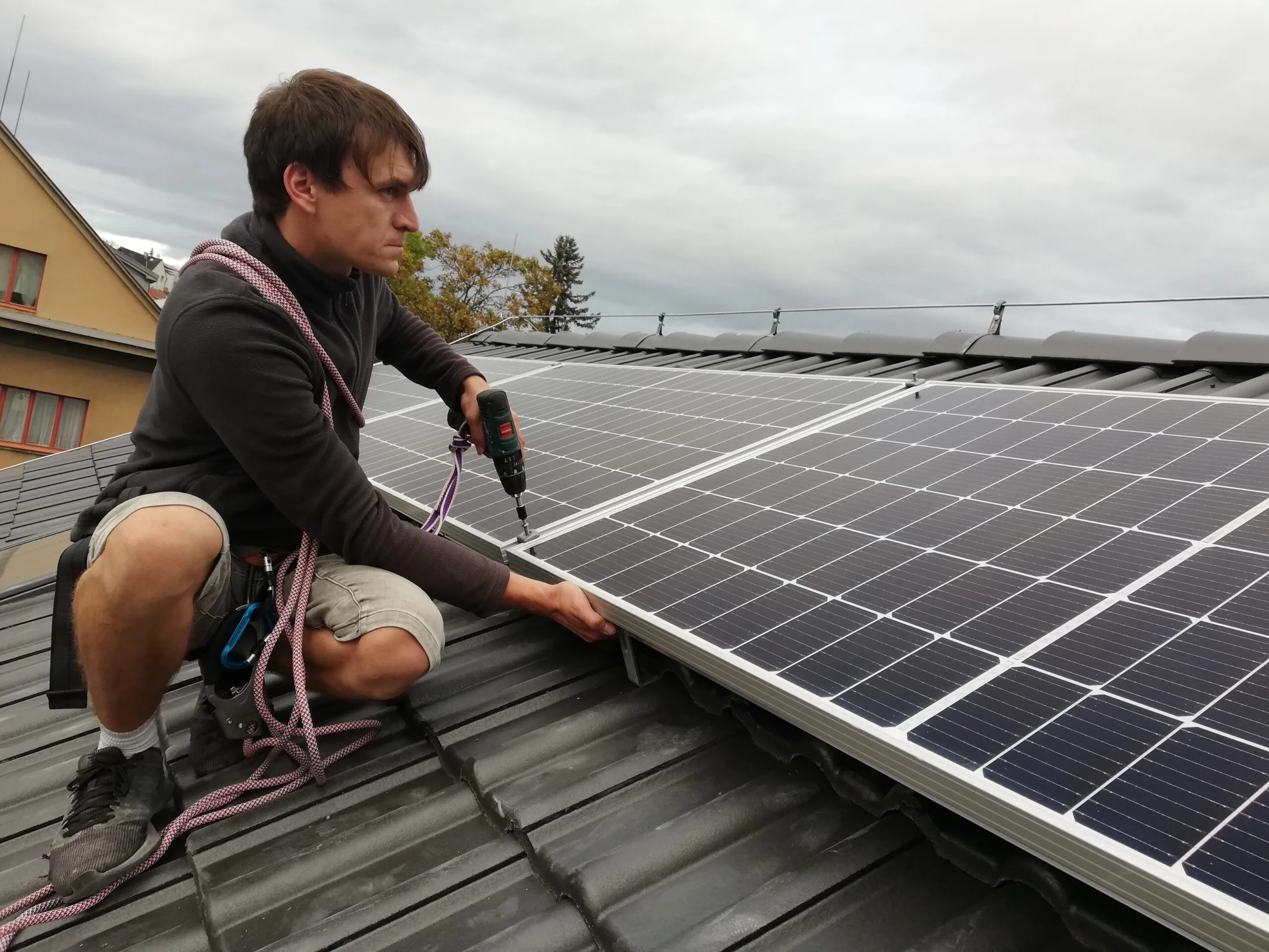 Technik při montáži fotovoltaických panelů na střeše rodinného domu v Praze