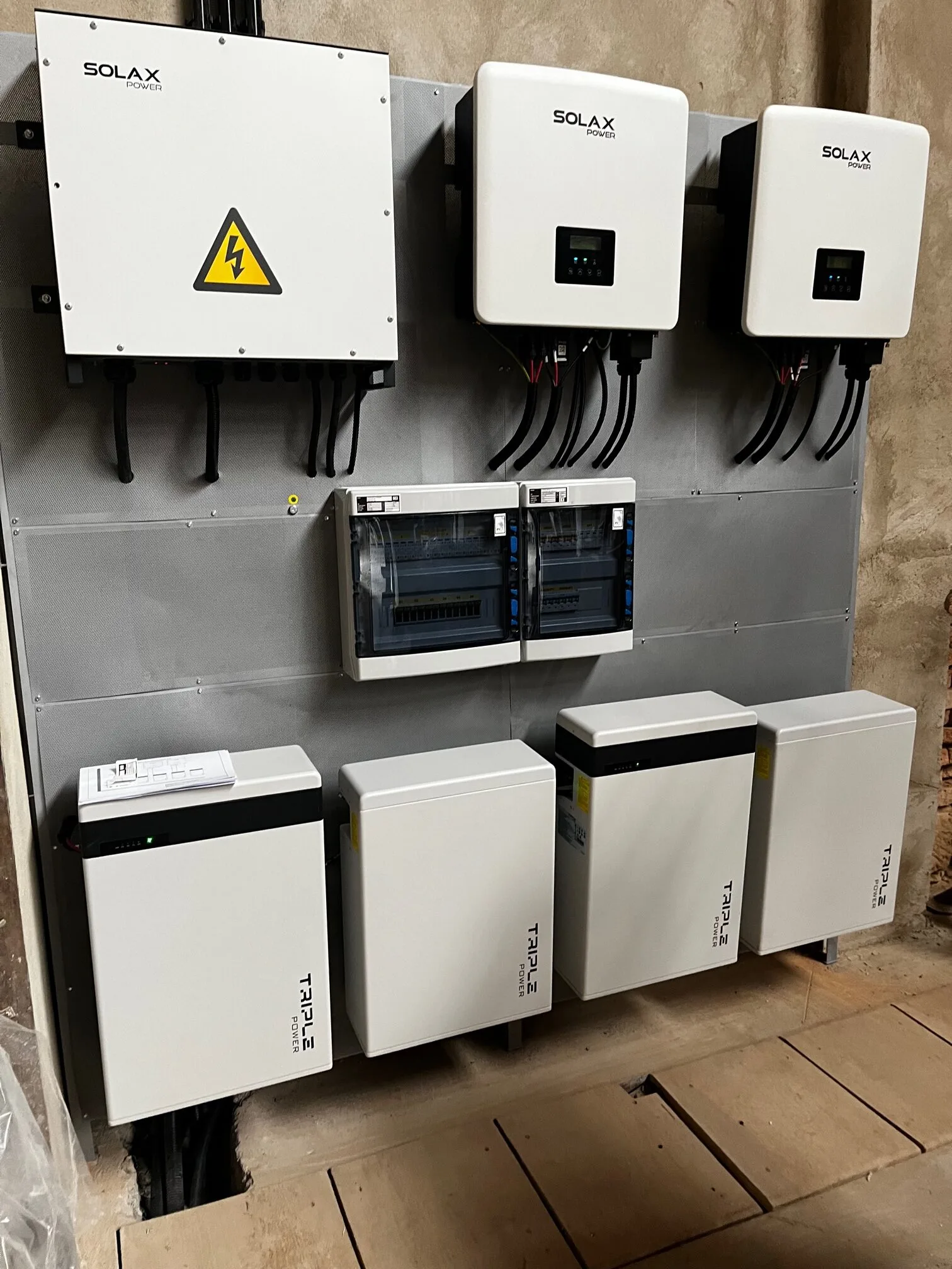 Dva hybridní střídače SolaX a bateriové moduly Triple Power na stěně technické místnosti